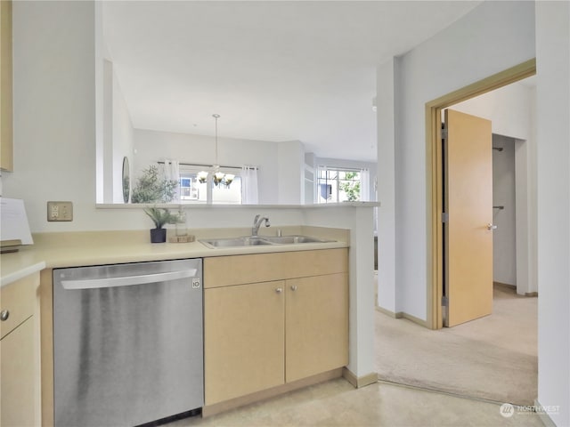 kitchen with light brown cabinetry, sink, hanging light fixtures, stainless steel dishwasher, and a notable chandelier