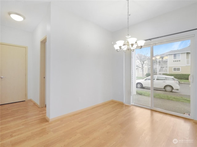 unfurnished room with a notable chandelier and hardwood / wood-style flooring