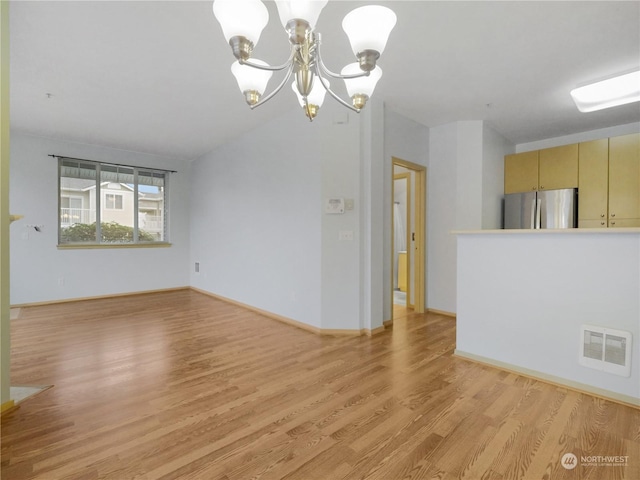 interior space featuring vaulted ceiling, a chandelier, and light wood-type flooring