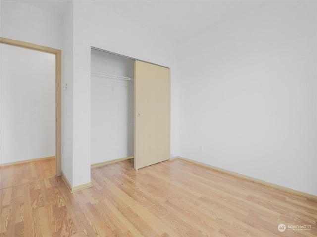 unfurnished bedroom with a closet and light hardwood / wood-style flooring