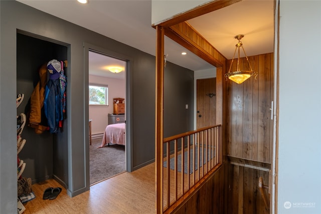 hallway with wood walls and light carpet