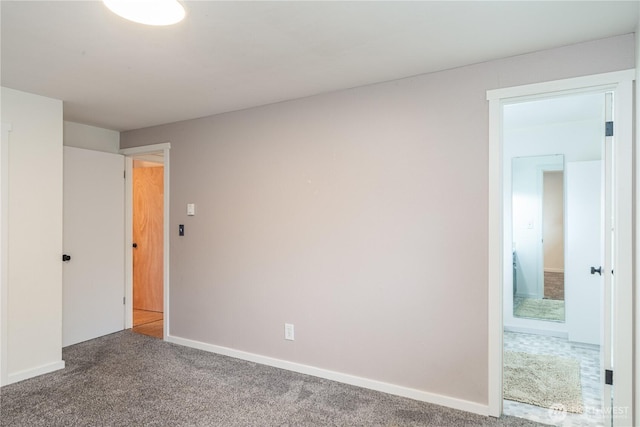 unfurnished room with carpet flooring and baseboards