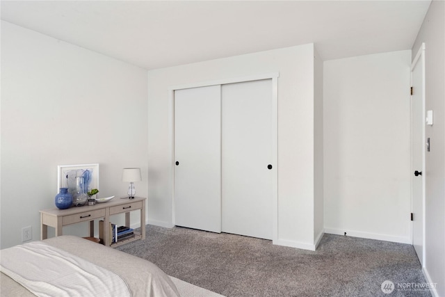 bedroom with carpet, baseboards, and a closet