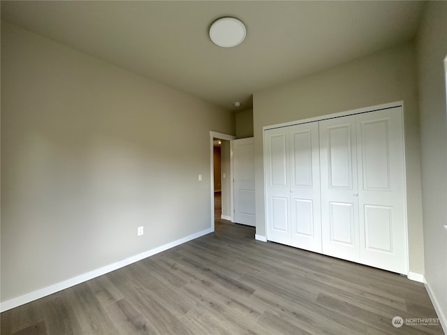 unfurnished bedroom with a closet and light hardwood / wood-style flooring