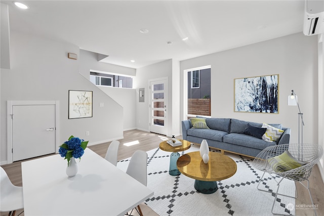 living room featuring a wall unit AC and light wood-type flooring