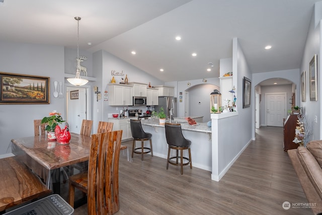 dining area with hardwood / wood-style flooring and vaulted ceiling