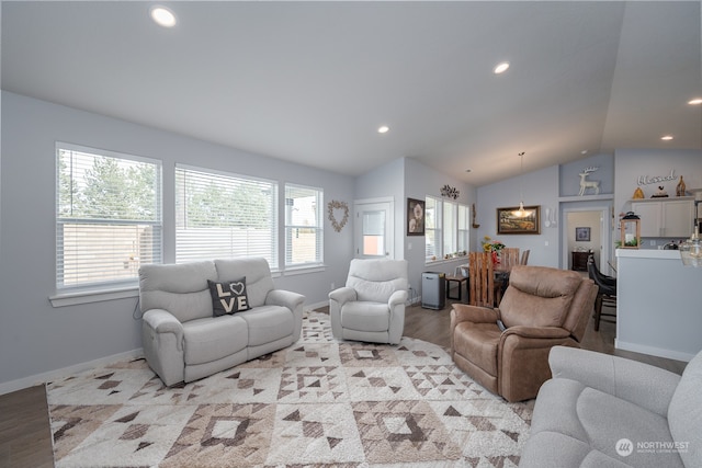 living room with lofted ceiling, a wealth of natural light, and light wood-type flooring