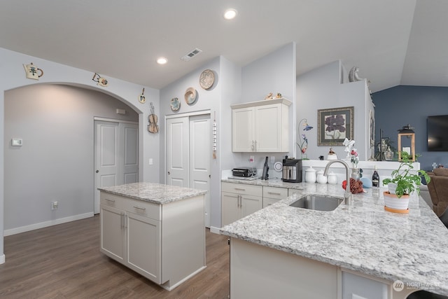 kitchen featuring lofted ceiling, sink, a center island, and hardwood / wood-style flooring