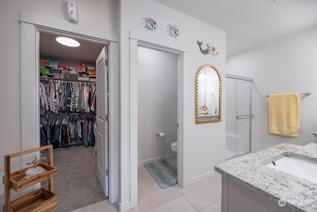 bathroom with toilet, an enclosed shower, vanity, and tile patterned floors