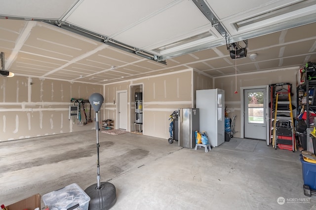 garage with a garage door opener and white refrigerator