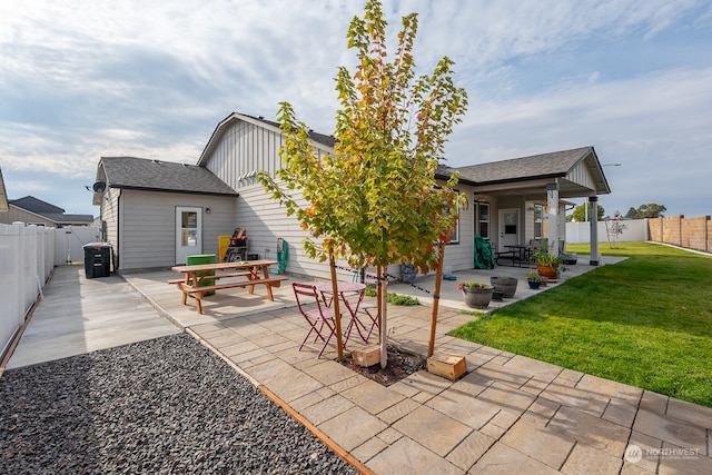 rear view of property featuring a patio and a yard