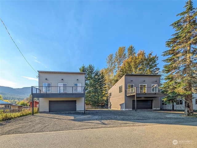 view of front facade featuring a mountain view, a balcony, and a garage