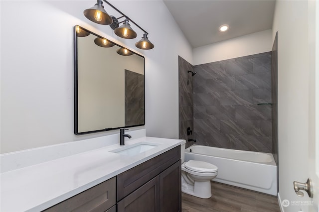 full bathroom with toilet, tiled shower / bath combo, hardwood / wood-style flooring, and vanity