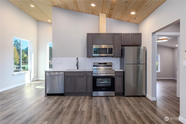 kitchen with hardwood / wood-style flooring, appliances with stainless steel finishes, sink, and wooden ceiling