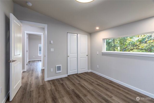 unfurnished bedroom featuring vaulted ceiling and dark hardwood / wood-style floors