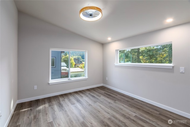 unfurnished room with light hardwood / wood-style floors and lofted ceiling