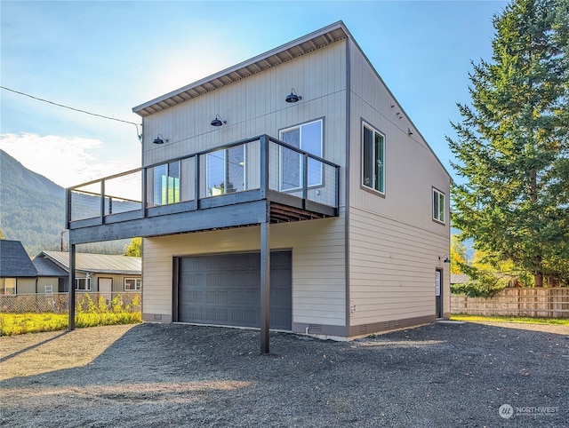 view of front facade featuring a balcony, a garage, and a mountain view