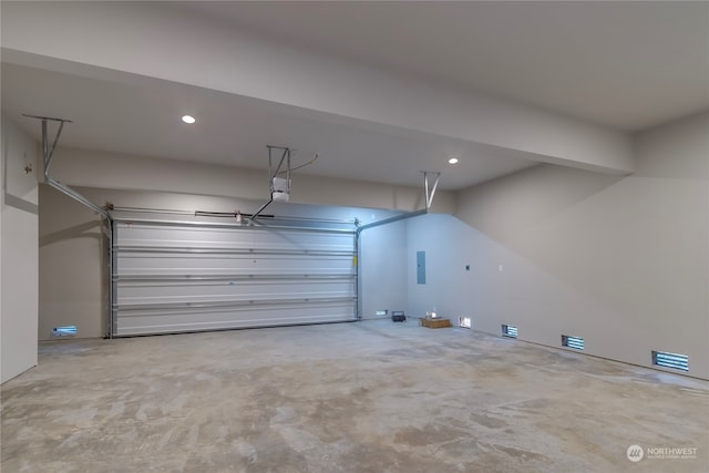 garage with a garage door opener and electric panel