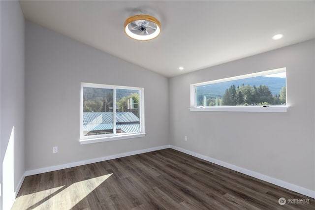 unfurnished room featuring ceiling fan, vaulted ceiling, and dark hardwood / wood-style flooring