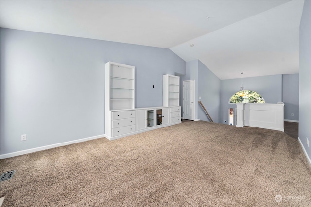 unfurnished living room with carpet, vaulted ceiling, and built in features