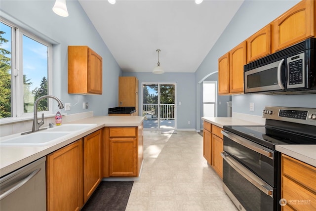 kitchen featuring plenty of natural light, appliances with stainless steel finishes, vaulted ceiling, and pendant lighting