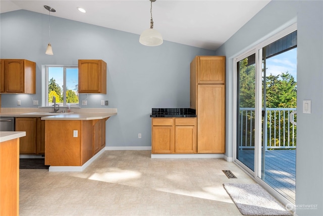 kitchen with stainless steel dishwasher, sink, vaulted ceiling, and pendant lighting