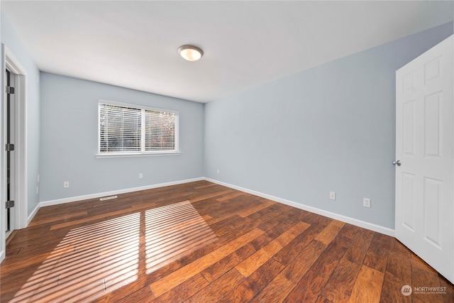 empty room with dark hardwood / wood-style floors