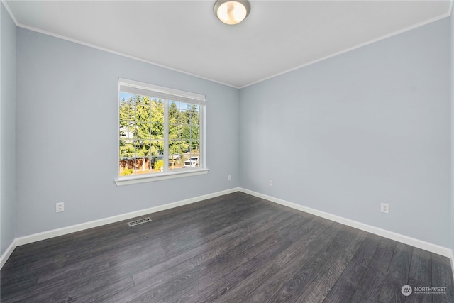 empty room featuring ornamental molding and dark hardwood / wood-style flooring