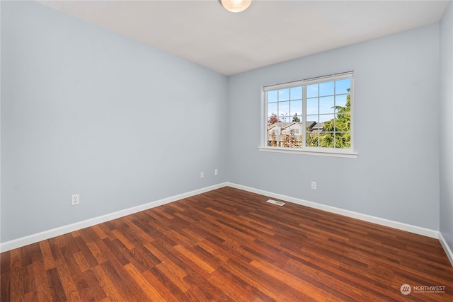 empty room with dark hardwood / wood-style flooring