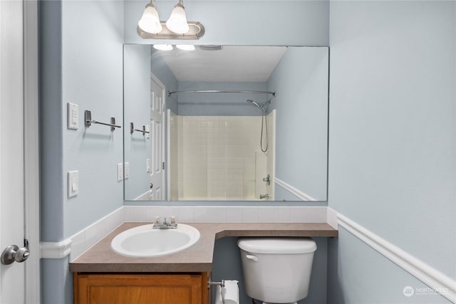 bathroom featuring vanity, toilet, and a shower