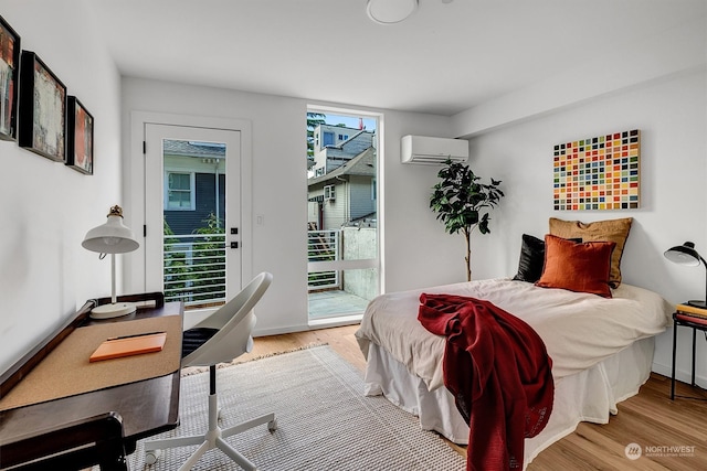 bedroom with access to exterior, multiple windows, light hardwood / wood-style flooring, and a wall mounted AC