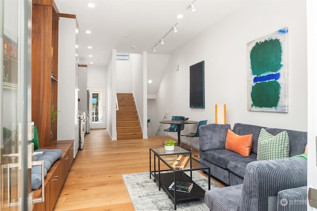 living room with light hardwood / wood-style floors and track lighting