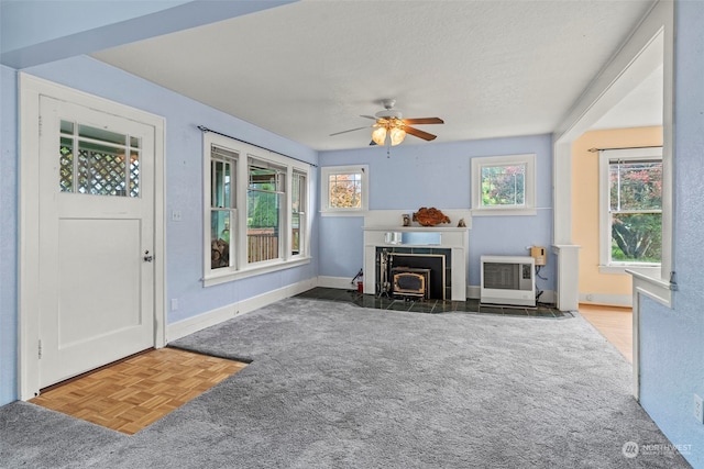 living room with a textured ceiling, dark parquet floors, heating unit, and ceiling fan