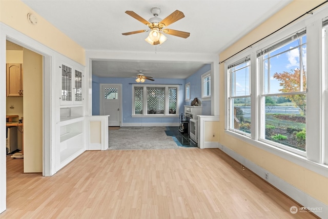 interior space with ceiling fan and a wood stove