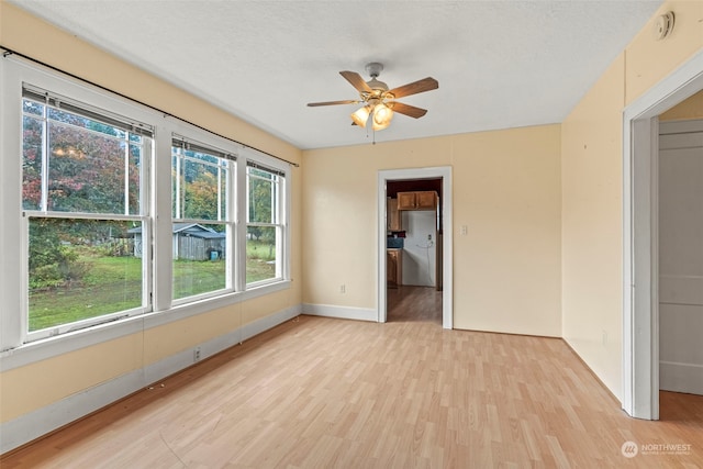 spare room featuring ceiling fan, a textured ceiling, and light wood-type flooring