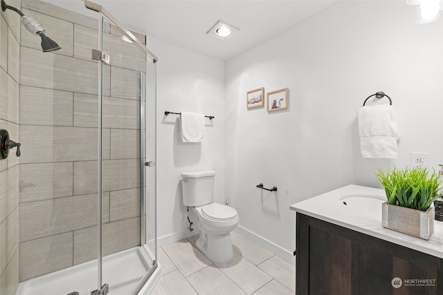 bathroom featuring vanity, toilet, and a shower with door