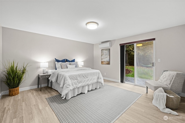 bedroom with light wood-type flooring, a wall mounted air conditioner, and access to exterior