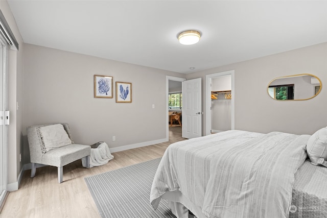 bedroom with a closet, a spacious closet, and light hardwood / wood-style floors