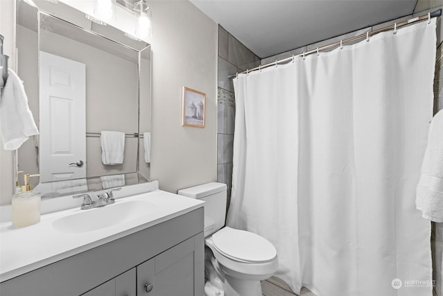 bathroom with curtained shower, vanity, and toilet