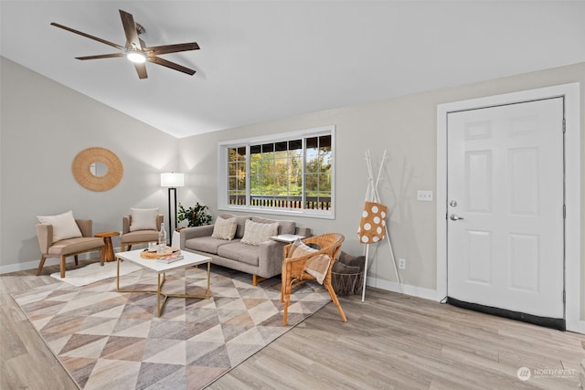 living room with light hardwood / wood-style floors, ceiling fan, and lofted ceiling