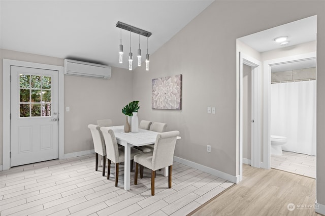 dining space with an AC wall unit, light wood-type flooring, and vaulted ceiling