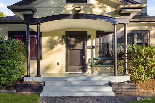 view of exterior entry featuring covered porch