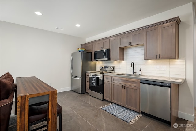 kitchen featuring appliances with stainless steel finishes, tasteful backsplash, and sink