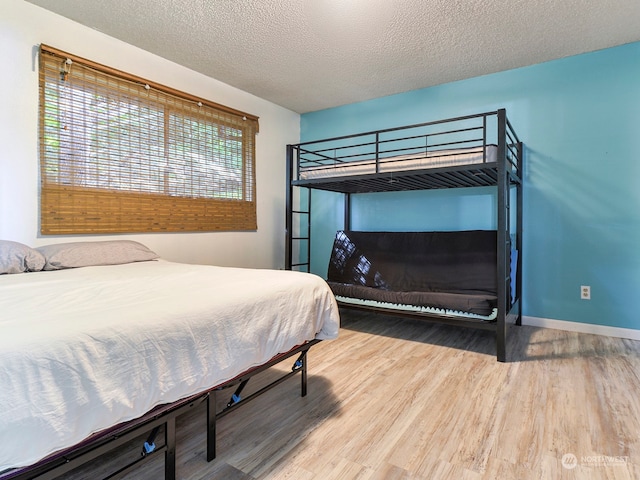 bedroom featuring hardwood / wood-style flooring and a textured ceiling