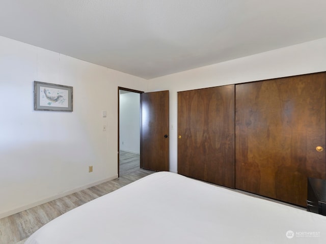 bedroom with a closet and light hardwood / wood-style floors