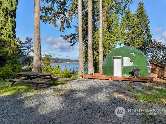 view of yard with a storage shed and a water view