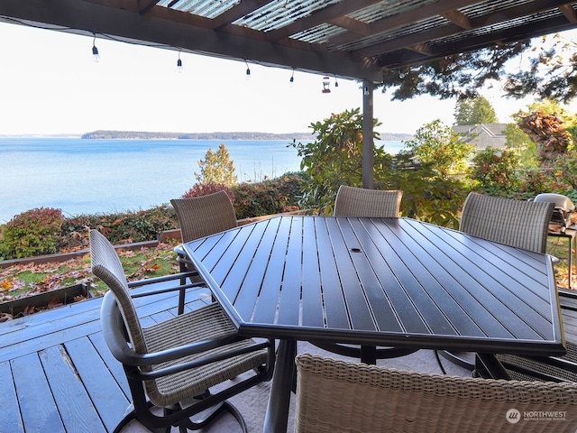 deck with a water view and a pergola