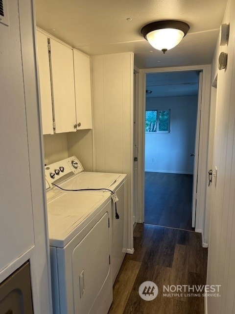 laundry room featuring cabinets, separate washer and dryer, and dark hardwood / wood-style flooring