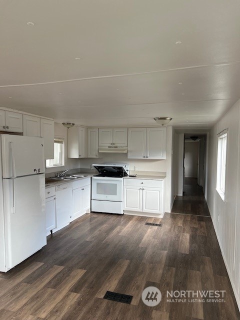 kitchen with white cabinets, dark hardwood / wood-style floors, white appliances, and plenty of natural light