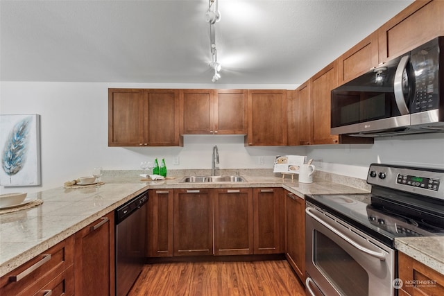 kitchen with rail lighting, light hardwood / wood-style flooring, stainless steel appliances, and sink